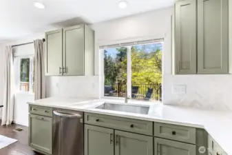 Herringbone tile backsplash contrasts the sparkling white quartz counters.  Functional deep sink and updated lighting. Newer appliances.