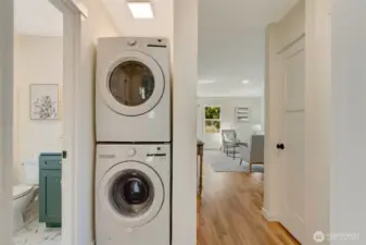 Stack washer and dryer with fan and light overhead.