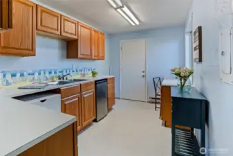 Kitchenette with mini fridge and sink.  There is space to add a dishwasher.  There are no cooking appliances in this space. The door leads to a craftroom.