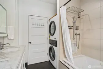 The spacious main-floor bathroom offers convenient laundry- new Electrolux washer & dryer-2025.