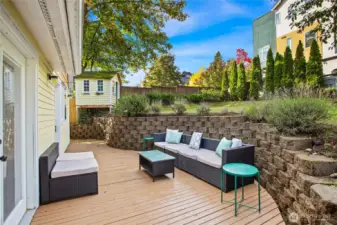 Weatherproof decking flanks the back of the home. Intricate hardscaping creates a lovely space to relax and entertain.  Continue around the south side of the home to find a second deck area seen in next photo.