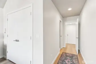 Hall to the primary bathroom, looks at the laundry closet