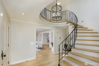 Elegant high ceiling entry way with curved staircase