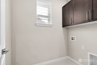 Upstairs laundry room with built in cabinets.