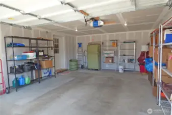 Attached double garage with remote opener. Shelving and frig stay too (still have items to remove).