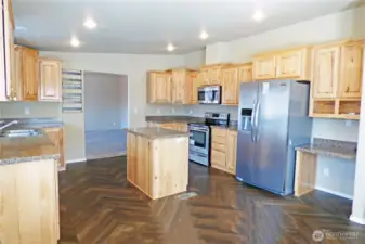 The other side of the kitchen with stainless appliances and a desk for paying bills or planning meals.