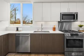 Quartz counters and stainless appliances with gas range and microwave built in over range.