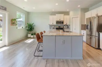 Flooded with natural light, this modern kitchen shines with a spacious island, stainless steel appliances, granite counters, and a layout that’s both stylish and functional.