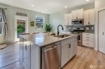 Cook, gather, and entertain with ease in this light-filled kitchen featuring a huge island, stainless steel appliances, and direct access to the backyard oasis.
