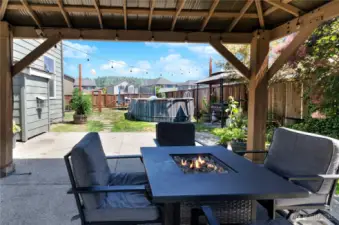 Enjoy your own private outdoor retreat—complete with a cozy fire table, covered patio, pool, string lights, and plenty of space for grilling, gardening, and entertaining all summer long.