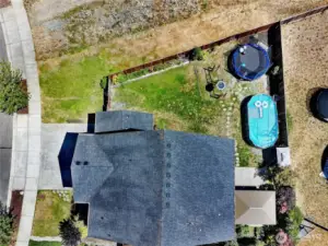 This aerial view showcases the full potential of the backyard—featuring a spacious layout perfect for entertaining, relaxing, or playing. The pool and trampoline can stay, creating an instant outdoor retreat that’s ready for summer fun!