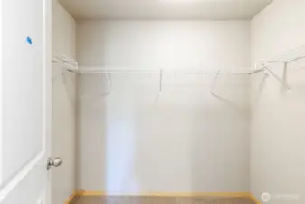 Spacious walk-in closet with built-in shelving.
