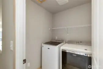 Convenient laundry room with washer, dryer, and storage.