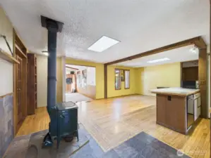 Hard wood floors and stone entry great you as you enter home past a charming wood burning stove.