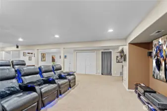 Large basement space designed for family time and entertaining features a full theater setup—ideal for movie nights, game days, and gatherings with friends and family.