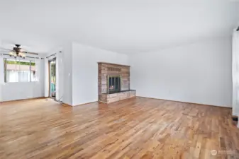 The living room is a bright and inviting space, featuring windows that flood the room with natural light. A central fireplace adds warmth and charm, creating a cozy focal point for gatherings.