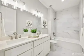 A luxurious feel to the lower level hall bath, dressed in quartz and extensive tile.