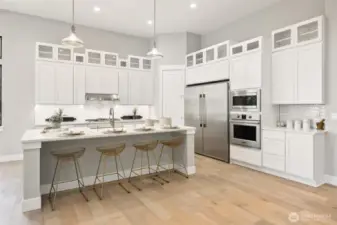 The vibrant and sophisticated kitchen dazzles with its glossy white backsplash, expanded cabinetry with glass accents, sleek stainless appliances, and slab quartz benchtops.