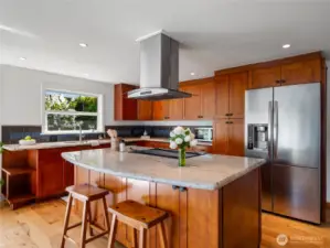 Kitchen has slab granite countertops, stainless steel appliances and a breakfast bar.