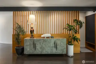 This entry space is gracious enough to accommodate a sizeable credenza.  In addition to paying homage to its midcentury roots, the slatted entry wall grants light into the hallway and stairwell.