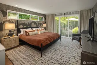 The Primary Suite is gracious in scale and beautifully-appointed, with designer wallpaper and sheer/blackout drapes.  A slider opens to a sweet patio.