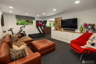 This fun space easily accommodates TV/lounging, and work-out gear; with a wall of built-ins adding style and function.  A sweet home office lives in that room straight ahead...