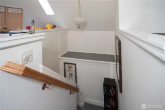 Stairway and landing has storage shelf.