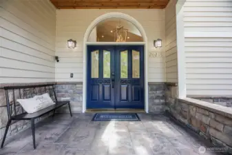 An inviting covered front porch with the continued stone accents.