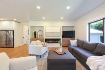 Family room with custom built-ins and 60” gas fireplace with ambient backlighting