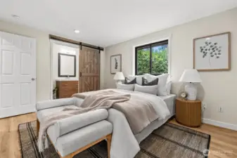 A custom oversized barn door serves as a functional piece of art, sliding back to reveal a spa-inspired en-suite retreat. It’s the perfect blend of architectural interest and effortless flow.