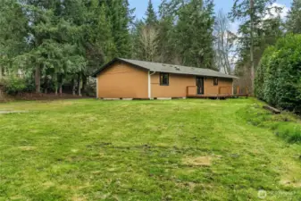 Escape the everyday in your own backyard retreat. This secluded deck provides a serene vantage point to enjoy the vast landscaping and quiet surroundings.
