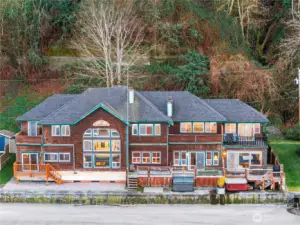 Waterfront residence featuring striking architectural windows, multiple decks for outdoor living, and sweeping views that bring the beauty of the shoreline right to your doorstep.