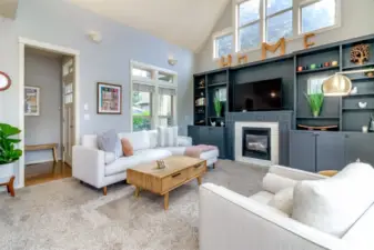 Vaulted great room with build-in cabinets, wood painted mantle, gas log fireplace and natural stone.