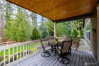 Serene covered back deck looking over greenbelt area