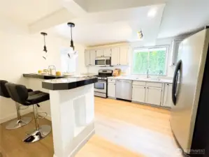 This remodeled kitchen offers a built-in bar area while giving ample kitchen space with a pantry.