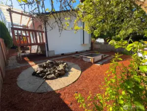 Side of the house has large firepit area with lots of space for gardening enthusiasts.