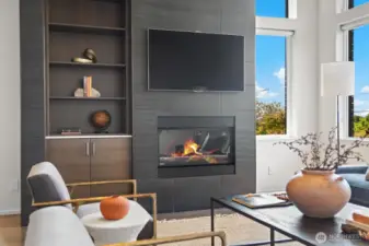 The fireplace wall featuring a gas fireplace, built-in walnut cabinetry, all wrapped in tile is the focal point of the living space