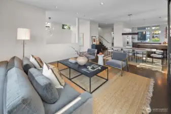 Living room looking back across the dining space towards the sunken entry and staircase to the bedroom level