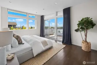 Primary suite with walls of windows and views of Green Lake, Downtown Seattle and the Olympic mountain range