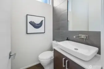 Powder room is tucked away from the great room spaces next to the office/den