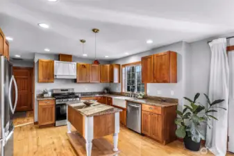 Light-filled kitchen features a practical layout with abundant cabinetry, durable surfaces, and a newly installed range. Positioned for connection to dining and living areas, this space supports both daily routines and gatherings.
