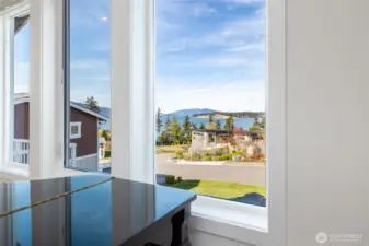 View looking outward from front window by piano in living room.