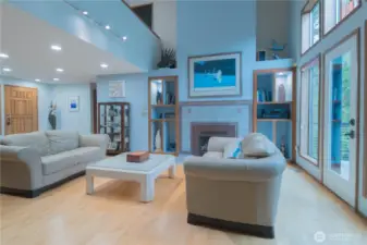 Large living room with cozy gas fireplace with maple hardwood floors and