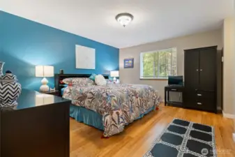 Primary suite. King bed with seating chair and 2 night stands.