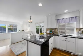 Charming kitchen with granite counters, white cabinetry, and dining nook.