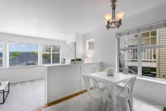 Light-filled dining area off kitchen with peek into sunken living room