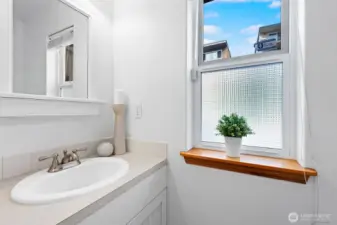 Bright main-level powder room with natural light and crisp finishes.