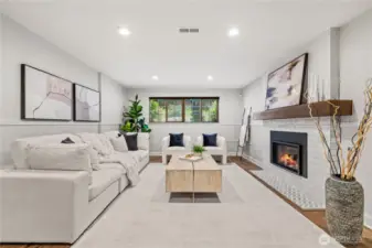The lower level features a generous second living area with a cozy fireplace, ideal for a playroom, home office, or a welcoming space for guests to unwind