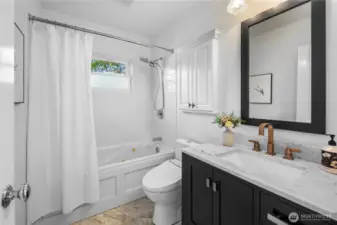 Full bath with newer vanity, lighting, and toilet.