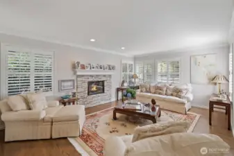 The elegant sunken living room exudes both sophistication and comfort. Gleaming hardwood floors and carefully chosen finishes enhance the room’s warm, inviting atmosphere. Large windows fill the space with natural light, while the sunken design creates a distinct, intimate area perfect for conversation, relaxation, or entertaining guests.